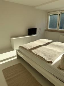 a white bedroom with a bed and a window at Casa Móre BEIGE in Niederalm