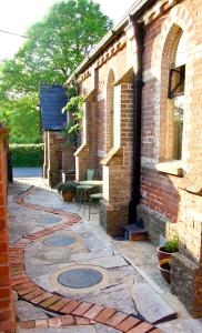 a brick building with a stone walkway in a yard at The Sunday Schoolroom in Sherborne