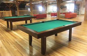 two pool tables in a room with red chairs at Hostel Międzynarodowe Centrum Spotkań Młodzieży in Toruń