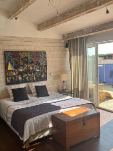 ein Schlafzimmer mit einem großen Bett und einem Gemälde an der Wand in der Unterkunft Villa des palmiers in La Jarne