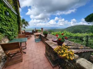 une terrasse avec des chaises, des tables et des fleurs dans l'établissement Casa MarJù, à Montemassi