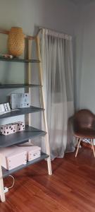 uma prateleira num quarto com uma cadeira e uma escada em Αναστασία 