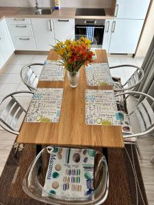 a kitchen with two wooden tables and a vase of flowers at Princess City Centre Apartment in Poprad