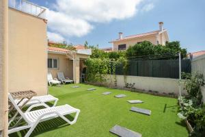 a backyard with lawn chairs and a fence at Cascais Alvide Guesthouse in Cascais