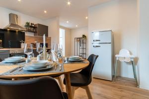 a kitchen with a wooden table with chairs and a refrigerator at RELAX-Apartment, Sauna, Free Coffee, 105m2 in Mühlacker