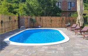 a swimming pool in a backyard with a wooden fence at Beautiful Home In Hrvatska Kostajnica With Wifi in Hrvatska Kostajnica