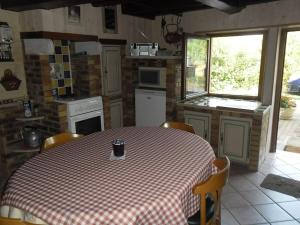 a kitchen with a table with a checkered table cloth at GITE LA FERMETTE A DOCELLES in Docelles