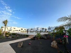 Un patio de recreo con rocas, plantas y edificios. en FTV Holidays Homes - Casa Relán, en La Oliva