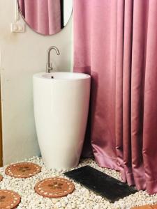 baño con lavabo y cortina de ducha rosa en กอบสุข รีสอร์ท2 k04, en Ban Ton Liang