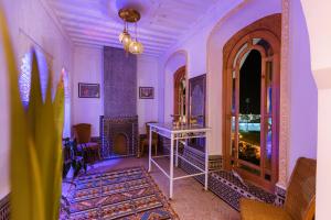 Riad Villa with Mediterranean Sea Views of Spain and Gibraltar في طنجة: غرفة بجدران أرجوانية وطاولة