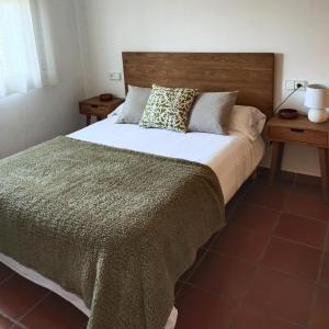 1 dormitorio con 1 cama grande y cabecero de madera en La Tenora, en Tivenys