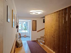 einen Flur mit holzgetäfelten Wänden und einer Treppe in der Unterkunft Haus Salzburgerland in Mauterndorf