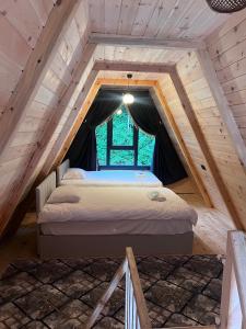uma cama no sótão de um chalé de madeira em Elegant Bungalov em Rize