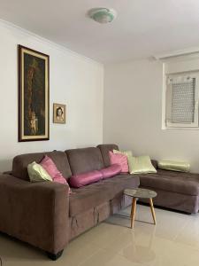 布德瓦Stan Budva - Potkosljun的客厅配有带色彩缤纷枕头的棕色沙发