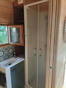 La petite salle de bains est pourvue d'une douche et d'un lavabo. dans l'établissement La roulotte de Jane, à Margon