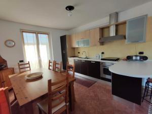 uma cozinha e sala de jantar com uma mesa e uma sala de jantar em Appartamento al Parco, Brentonico em Brentonico