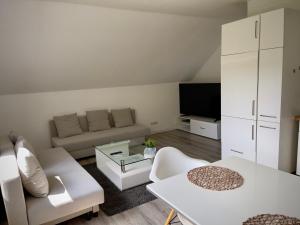 ein Wohnzimmer mit einem Sofa und einem Tisch in der Unterkunft Ferienwohnung am Wald in Haiterbach