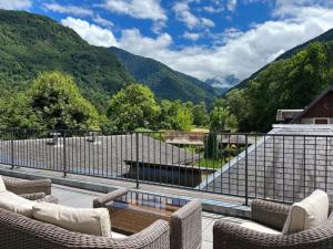 a balcony with chairs and a view of mountains at Hôtel La Rencluse in Luchon