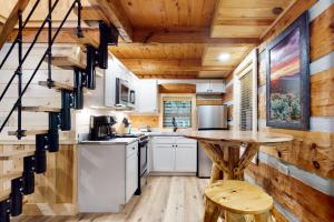 a kitchen with white appliances and a wooden ceiling at Up the Creek in Gatlinburg