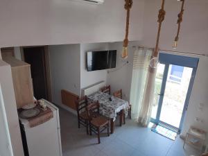 スキアトスタウンにあるSkiathos island houseのテーブルとテレビのあるキッチンとダイニングルーム