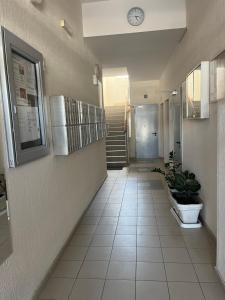 a hallway with a clock on the wall and a staircase at Studio Pao in Podgorica