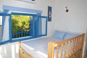 Cama en habitación con ventana en Villa Bellina, en Pefki