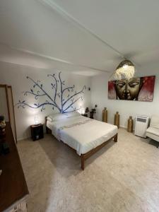 a bedroom with a bed with a painting on the wall at New Paradaise art Gallery in Xàtiva