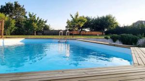 a large swimming pool in a yard with a wooden deck at VILLA RAFFAELLA in Les Albres