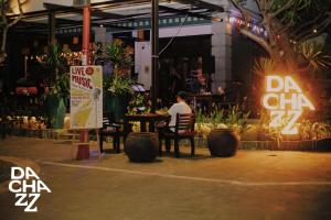 a man sitting at a table in a restaurant at night at Chu Hotel in Danang