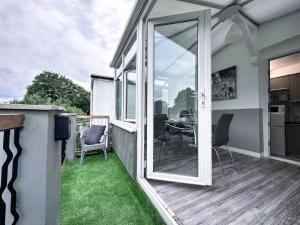 a balcony with sliding glass doors and a table with chairs at Sleek Skyward Serenity 2bed with Pool Table - Ystrad in Llwyn-y-pia