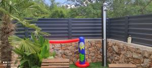 a playground with a red slide in a fence at Kuca za odmor Vugica in Polje