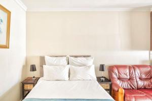 a bedroom with a bed and a leather chair at Goodwood Oasis Free WiFi-Parking 2 in Cape Town