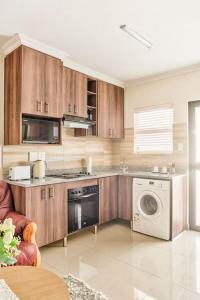 a kitchen with a stove and a washer and dryer at Goodwood Oasis Free WiFi-Parking 2 in Cape Town