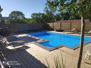 a swimming pool in a backyard with a wooden deck at Villa Chrysalide in Berrias Et Casteljau