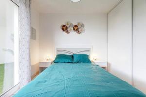 1 dormitorio con 1 cama azul y 2 mesitas de noche blancas en *ALCO Appart 2 chambres, WIFI, Parking, Terrasses*, en Montpellier