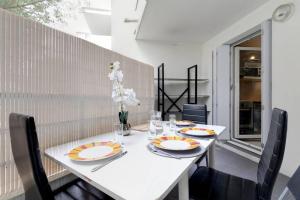 mesa de comedor con 2 platos y sillas en *ALCO Appart 2 chambres, WIFI, Parking, Terrasses*, en Montpellier