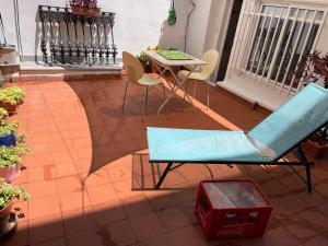 eine Terrasse mit einem blauen Sofa, einem Tisch und Stühlen in der Unterkunft Apartamento Valencia in Catarroja