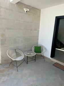 twee stoelen en een tafel naast een stenen muur bij Luxueuze villa Taghazout Bay in Taghazout