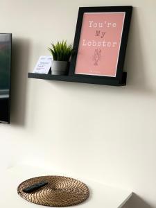 a shelf with a picture and a remote control on a desk at City Center Studio - 418 in Klaipėda