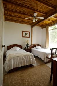 1 dormitorio con 2 camas y ventilador de techo en Misahualli Amazon Lodge, en Puerto Misahuallí
