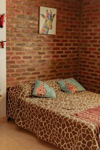1 dormitorio con cama y pared de ladrillo en Casa Africa, en Calima
