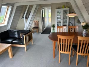 Nice holiday home in beautiful resort في Farsø: غرفة معيشة مع طاولة وكراسي