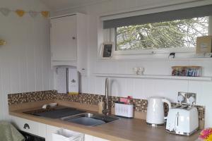 a kitchen counter with a sink and a window at Hillview Haven at Hillcrest in Liskeard