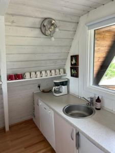 małą kuchnię ze zlewem i oknem w obiekcie Nice holiday home in beautiful resort w mieście Farsø
