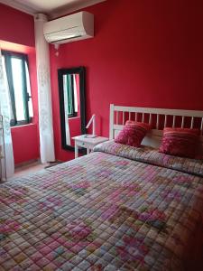 a bedroom with a large bed with red walls at Casa Tania in Pereto