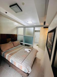 a bedroom with a bed and a tv in it at Netflix and Unli WIFI!!! The Elchies Room at Tagaytay Prime Residence in Tagaytay