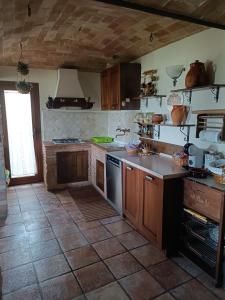 a kitchen with wooden cabinets and a tile floor at Casa Tania in Pereto