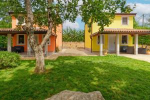 żółty dom z drzewem na podwórku w obiekcie Holiday Homes Sunny Twins by Rent Istria w mieście Grožnjan