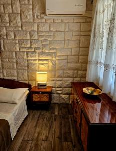 a bedroom with a bed and a table with a lamp at Small House Postup in Orebić