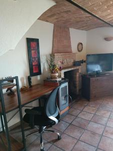 an office with a desk and a chair and a television at Casa Tania in Pereto